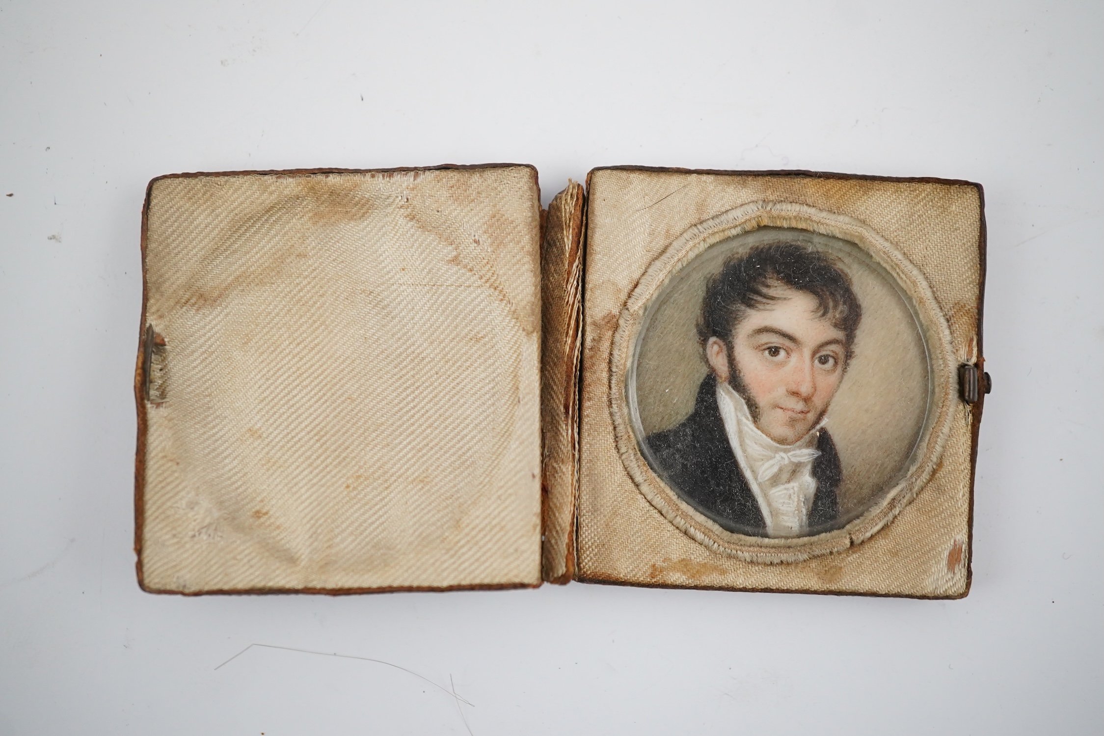 A mid 19th century French portrait miniature of a gentleman on ivory, in leather case inscribed 'Souvenir', 4.3cm high overall. CITES Submission reference V6R44LRJ. Condition - fair to good.